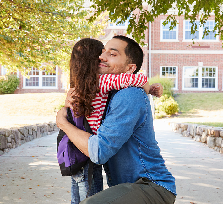 Dad hugging daughter before school