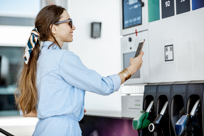 Woman smiling while using a MyFortiva credit card at the gas pump